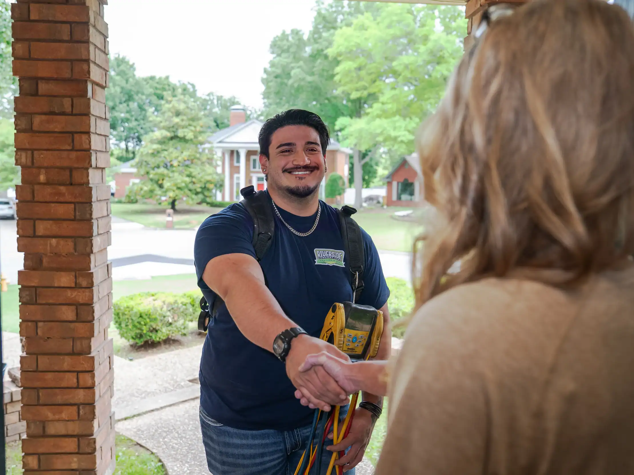 Riverside technician talking with a homeowner at the front door