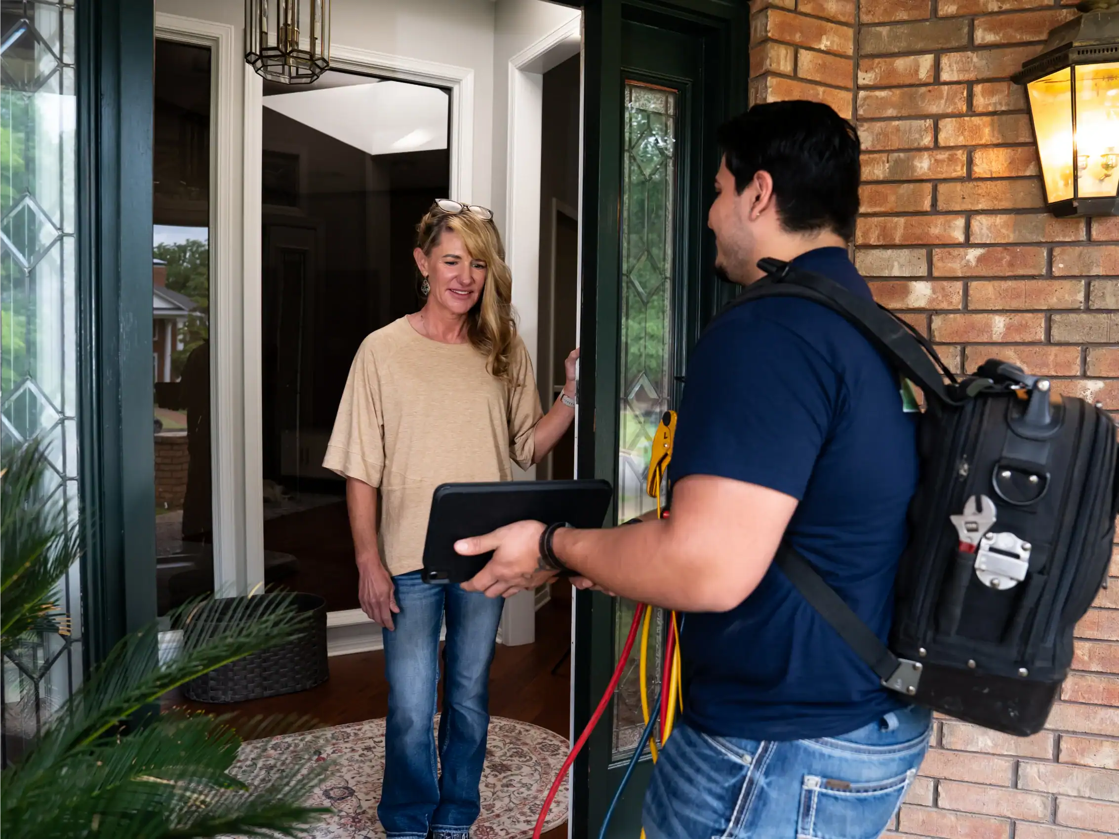 Riverside technician greeting a homeowner at the front door