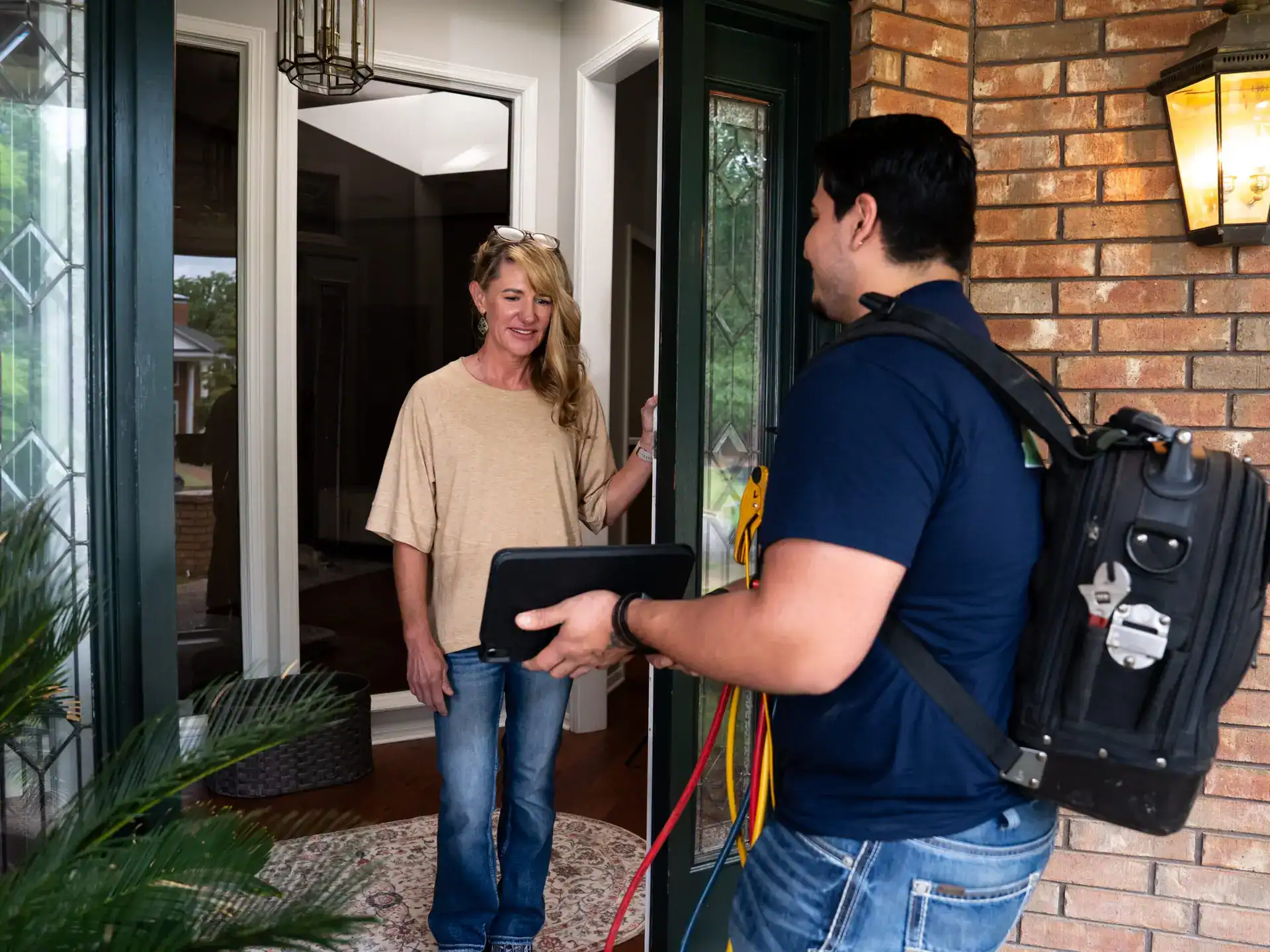 Riverside technician meeting a homeowner at the front door