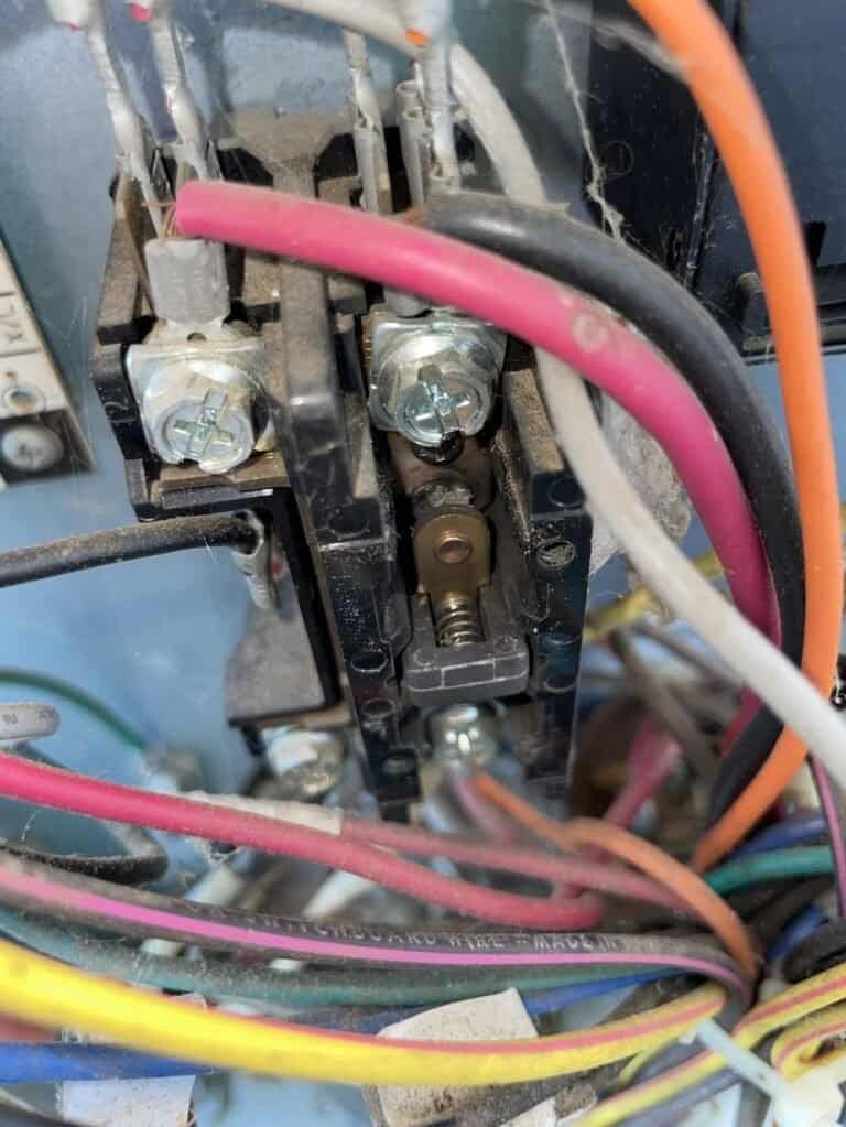 Worn contactor in the electrical compartment of a Booneville AC outdoor unit