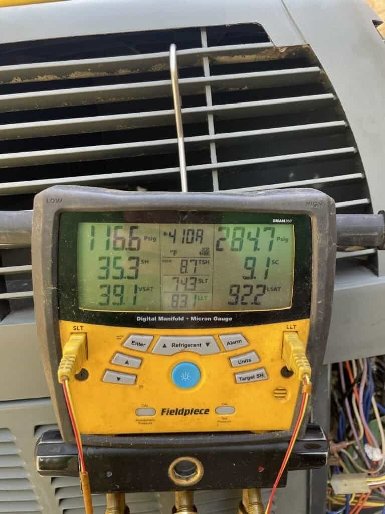 Digital refrigerant gauges connected to a Greenwood air conditioner during a diagnostic visit