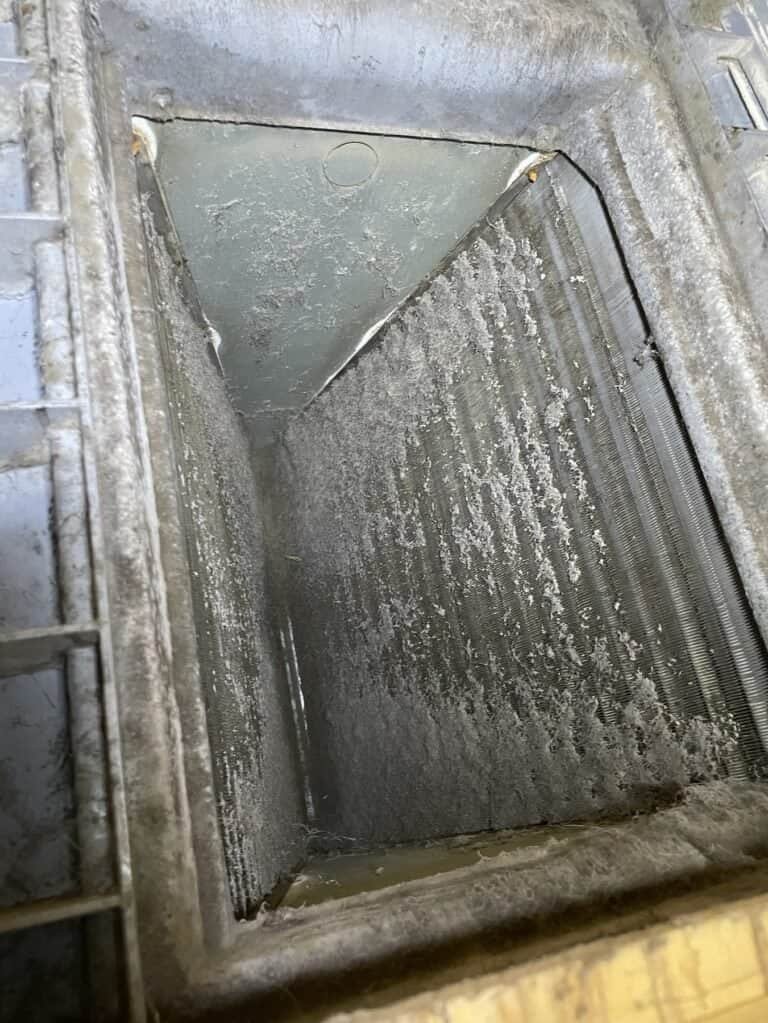 Dirt and dust built up on an indoor evaporator coil in a Van Buren home before cleaning