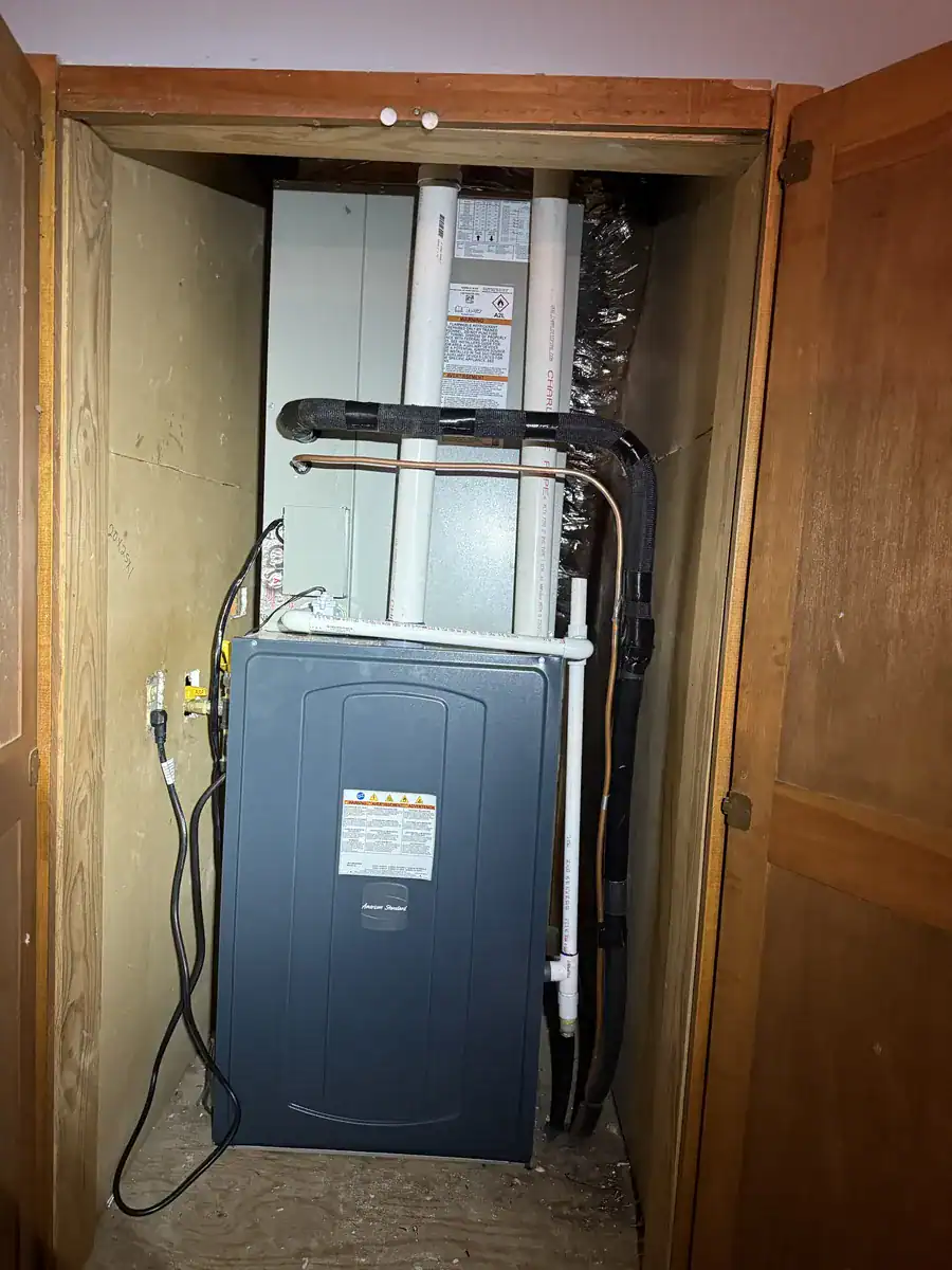 New American Standard gas furnace with matching coil on top, installed in a wood closet