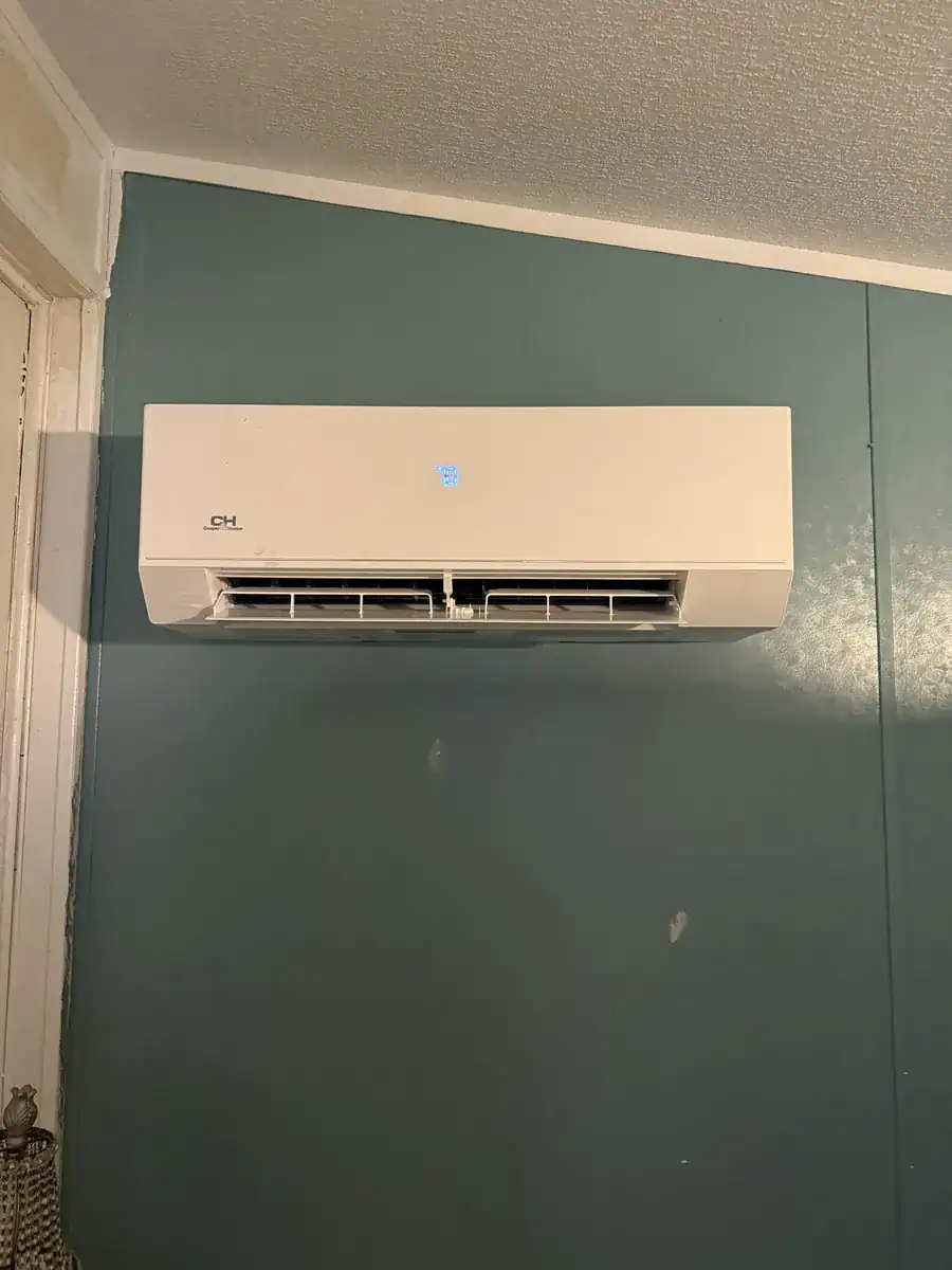 White Cooper and Hunter indoor wall unit mounted high on a teal wall