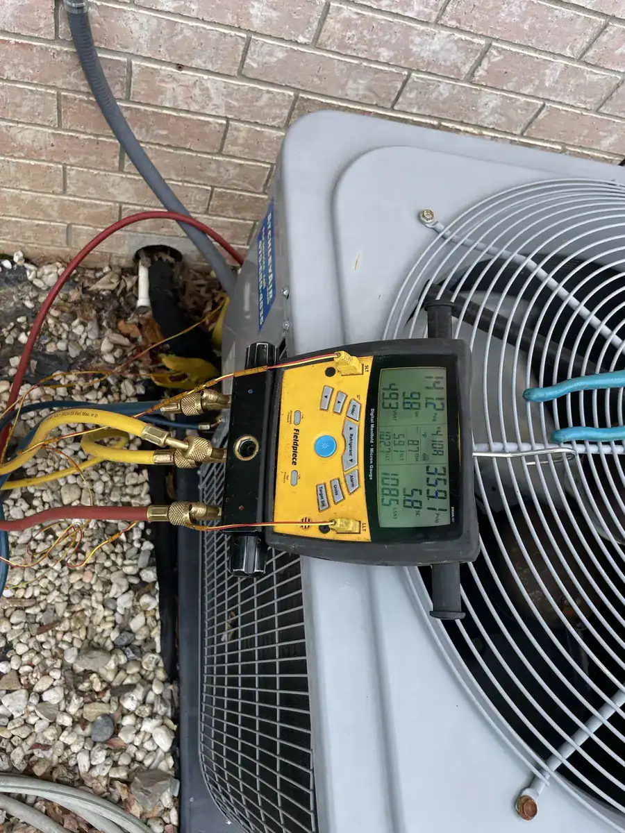 Pressure gauges hooked to a Fort Smith outdoor AC unit during a repair visit