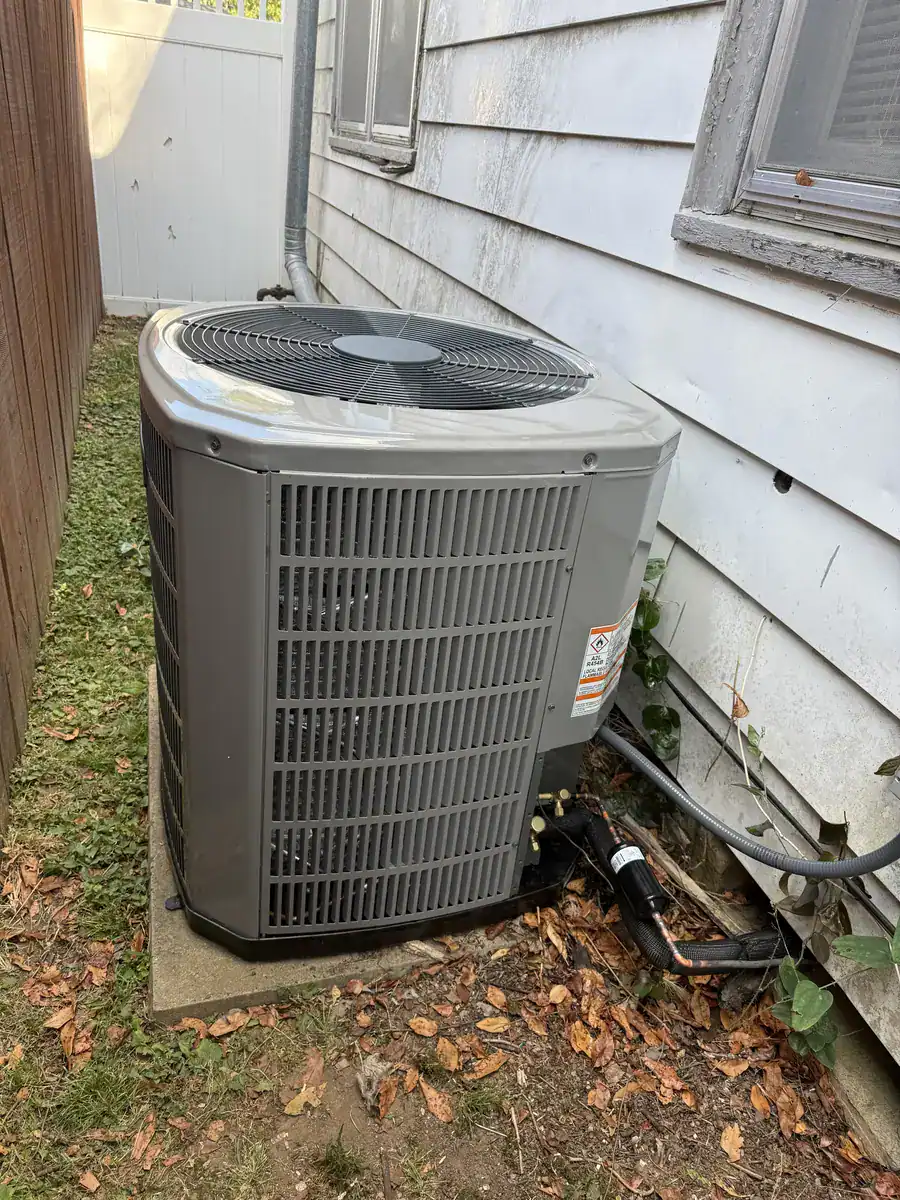 New outdoor AC unit set on a level pad beside a Fort Smith home