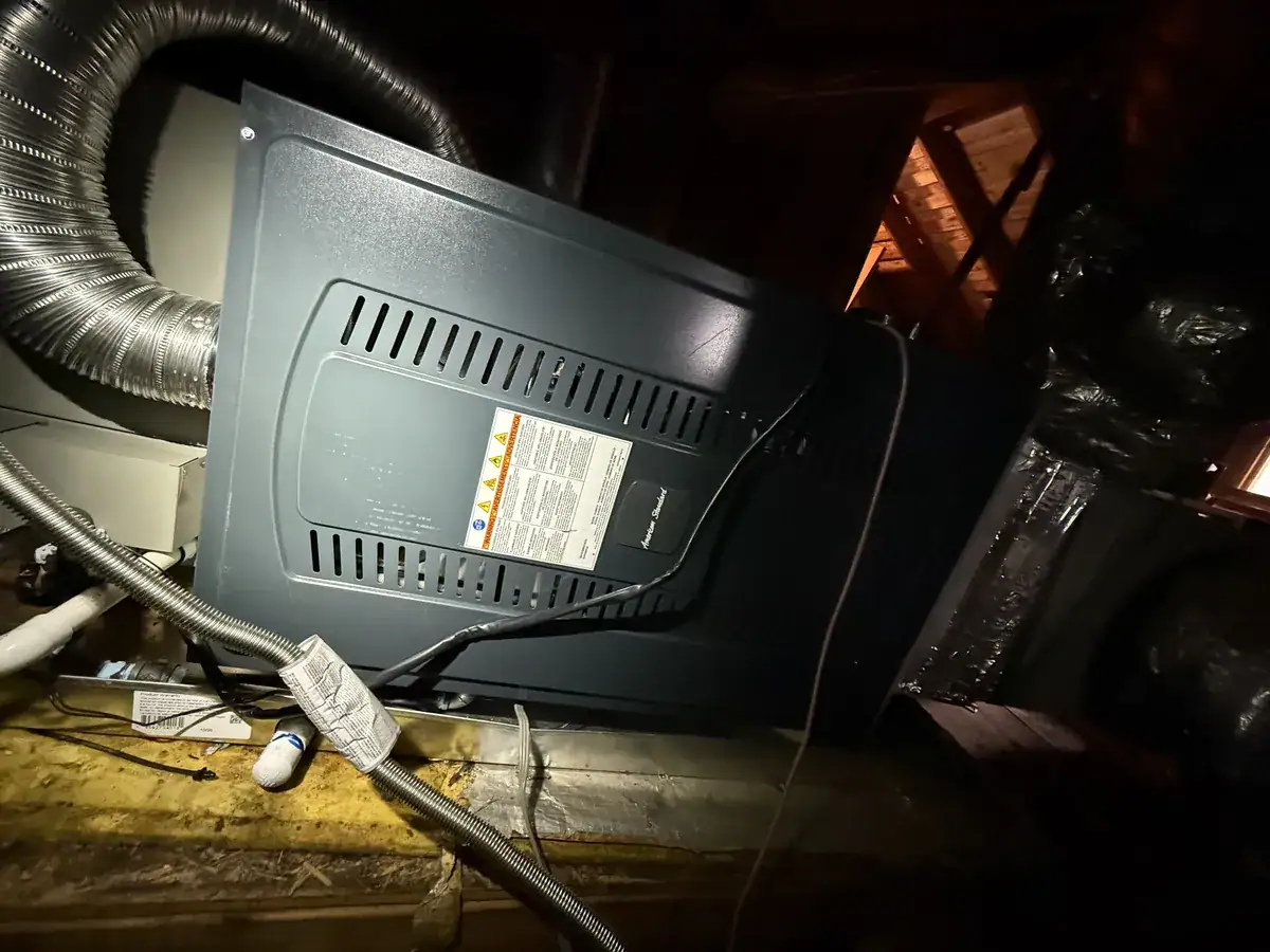 New gas furnace lying on its side in an attic with flexible duct attached