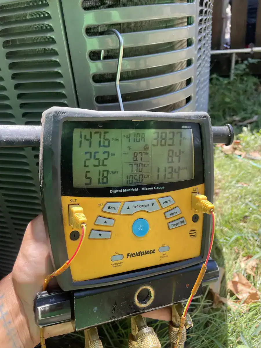 Technician reading pressure gauges at a Van Buren AC that was blowing warm air