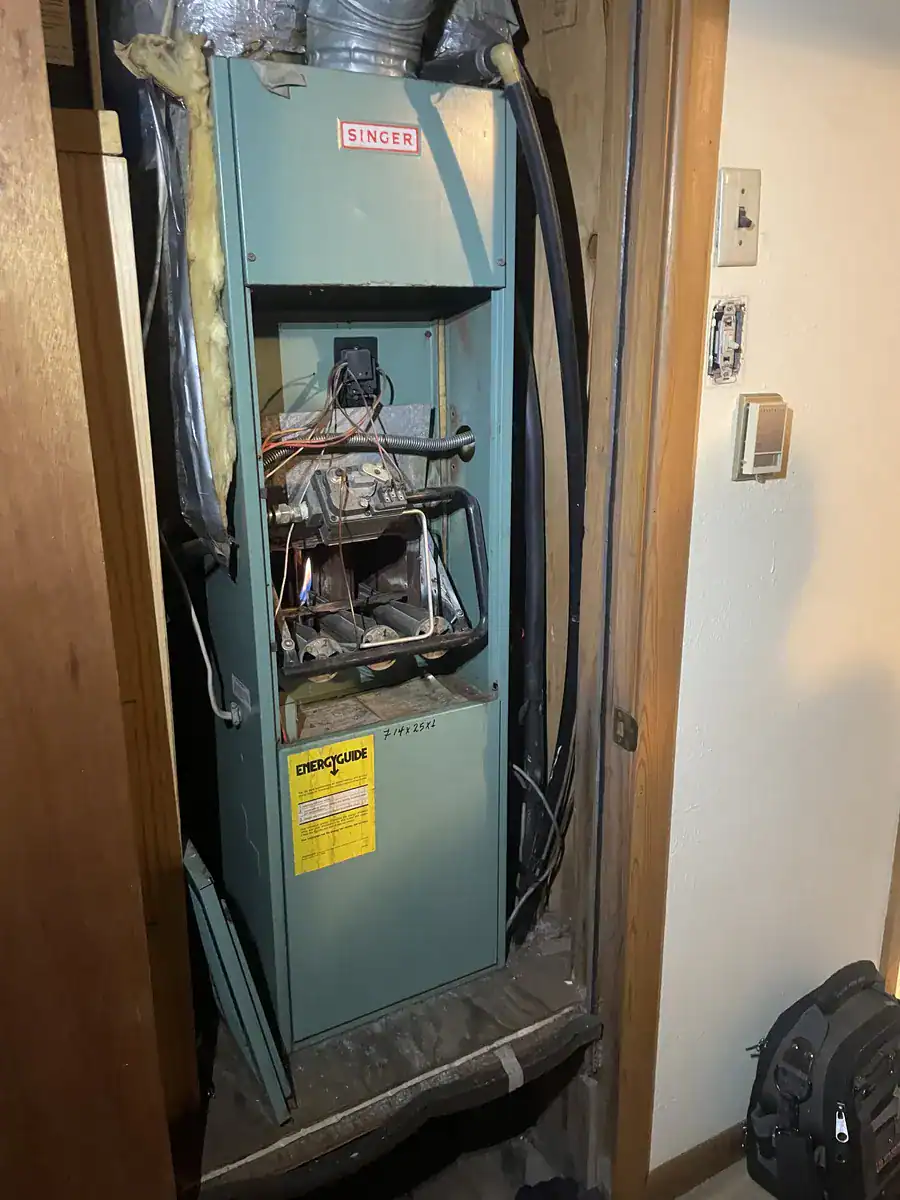 Gas furnace with the front panel off in a Van Buren utility closet