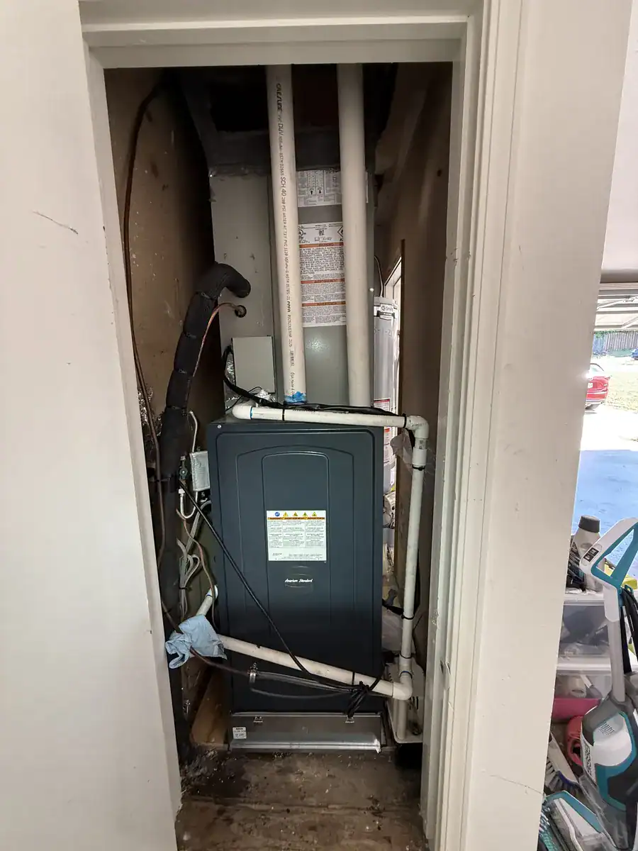 New American Standard gas furnace in a Van Buren closet, with its vent and drain pipes
