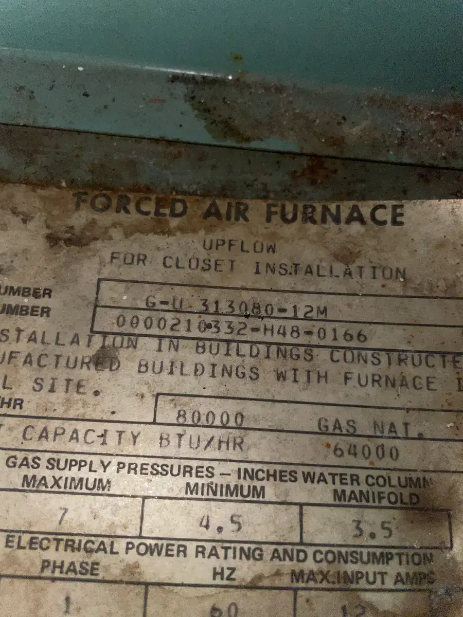 Model and serial number label on an older gas furnace in a Van Buren home